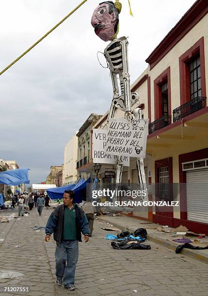 Un residente pasa el 14 de junio de 2006 bajo un esqueleto de carton que representa al gobernador Ulises Ruiz, despues de enfrentamientos entre...