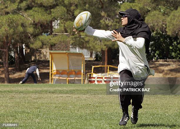 An Iranian woman meeting the Islamic dress code plays rugby at Tehran's Azadi stadium 15 June 2006. Under the Islamic republic's strict rules,...