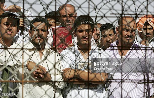Iraqi prisoners wait inside the compound shortly before they are released, as another batch of 200 prisoners are freed from Abu Ghraib prison on June...