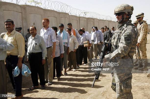 Soldiers stand on guard at the Abu Ghraib prison shortly before prisoners are released, as another batch of prisoners were freed under a national...