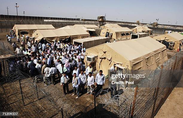 Iraqi prisoners wait inside the prison compound, shortly before another batch of 200 prisoners are freed from Abu Ghraib prison on June 15, 2006 in...