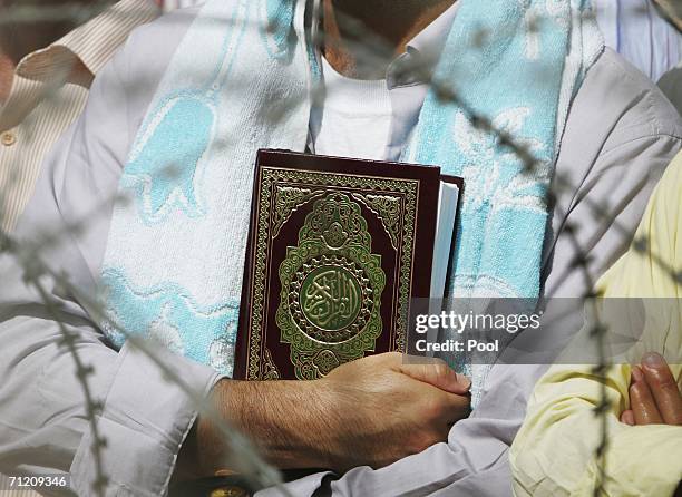 Detainee carries a Holy Koran while waiting to be freed as another batch of 200 prisoners are freed from Abu Ghraib prison on June 15, 2006 in...