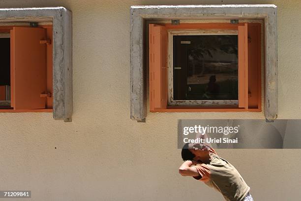 An Israeli school boy plays next to rocket proof classrooms in kibutz Yad Mordechay June 15, 2006 near the city of Sderot, Israel. A spokesman for...