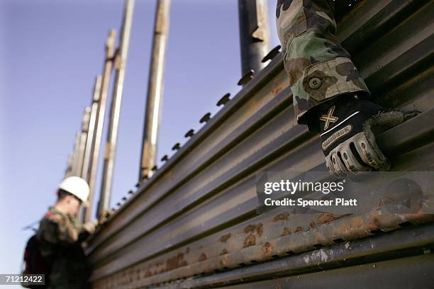 Members of the Utah Army National Guard unit 1457 work on new portions of the border fence along the Arizona-Mexico border June 15, 2006 in San Luis,...