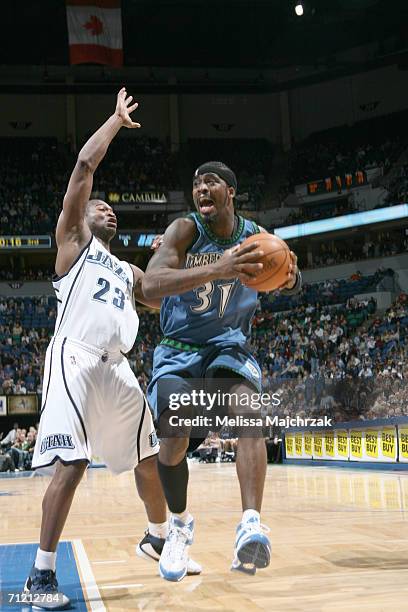 Ricky Davis of the Minnesota Timberwolves is defended by Devin Brown of the Utah Jazz during a game at Target Center on April 7, 2006 in Minneapolis,...