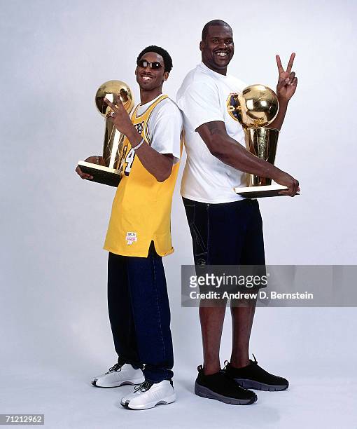 Kobe Bryant and Shaquille O'Neal of the Los Angeles Lakers pose for a portrait with two NBA Championship Trophies in 2001 in Los Angeles, California....