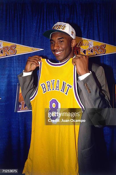 Kobe Bryant holds a Los Angeles Lakers jersey after being the 13th overall pick in the 1996 NBA Draft by the Charlotte Hornets who then traded his...