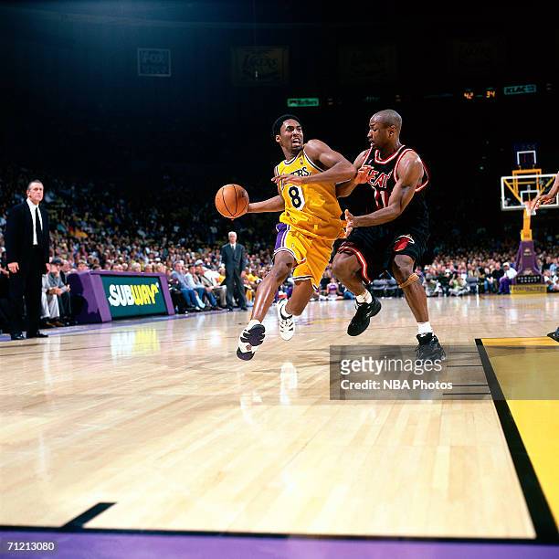Kobe Bryant of the Los Angeles Lakers drives to the basket against Travis Best of the Miami Heat during a game circa 1997-1999 at The Great Western...