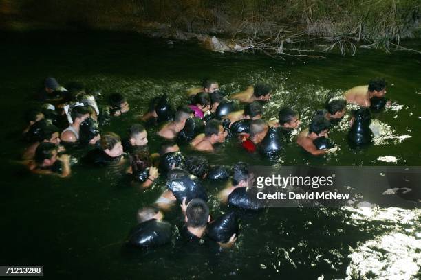 Group of migrants trying to illegally cross the border from Mexico to the U.S. Float down the polluted New River late at night on June 14, 2006 in...