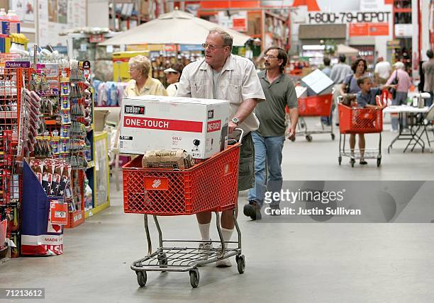 Home Depot customer pushes a shopping cart with a Weber barbecue grill at a Home Depot store on June 15, 2006 in San Rafael, California. Retail...