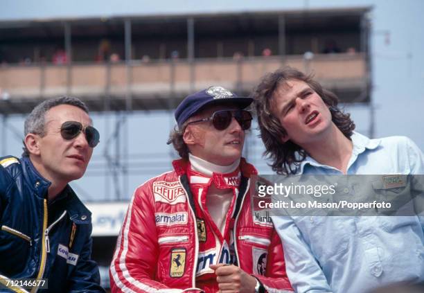 Niki Lauda of Austria who finished second, driving a Ferrari 312T2 with a Ferrari 015 3.0 F12 engine for Team Scuderia Ferrari SpA SEFAC, talking to...
