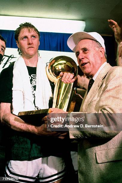 Larry Bird of the Boston Celtics poses with General Manager Red Auerbach after winning the 1986 NBA Championship by defeating the Houston Rockets in...
