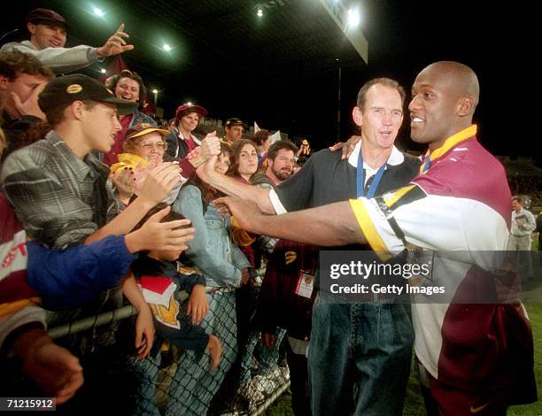 Wendell Sailor of the Broncos and coach Wayne Bennett celebrate victory with fans after the Super League Grand Final between the Brisbane Broncos and...