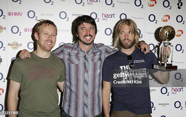 Nate Mendel, Dave Grohl and Taylor Hawkins of Foo Fighters, winners of the International Award pose in the awards room at the O2 Silver Clef Lunch,...