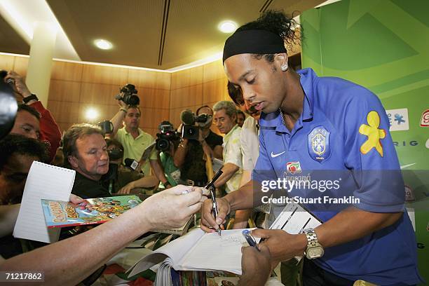 Ronaldinho of Brazil signs autographs for memebers of the media as he leaves the press conference of the Brazilian National Team for the FIFA World...