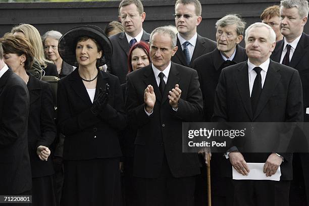Irish President Mary McAleese and husband Martin applaud after Irish Prime Minister Bertie Ahern's graveside oration at the State Funeral of former...