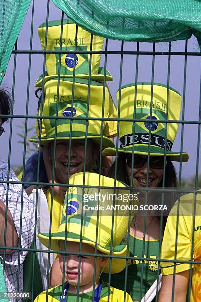 German supporters wearing top hats with Brazil's colours observe the team's training through a fence, 16 June 2006, at the Zagallo Arena in...