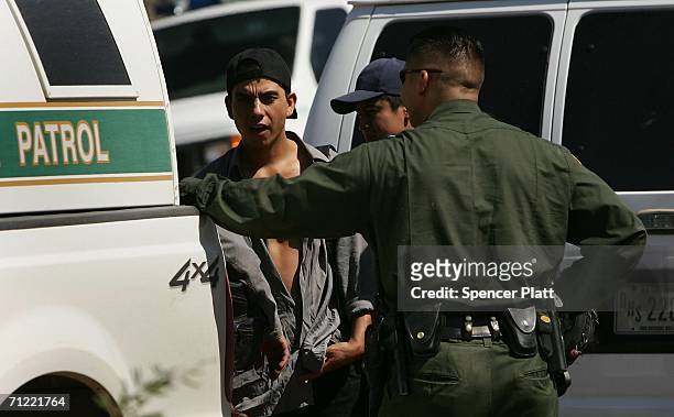 Border Patrol agents detain a man caught after illegally crossing the border with Mexico June 16, 2006 in Pima County, Arizona. President George W....