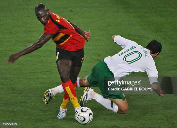 Angolan midfielder Andre tackles Mexican forward Guillermo Franco during the 2006 World Cup Group D football match Mexico vs. Angola, 16 June 2006,...