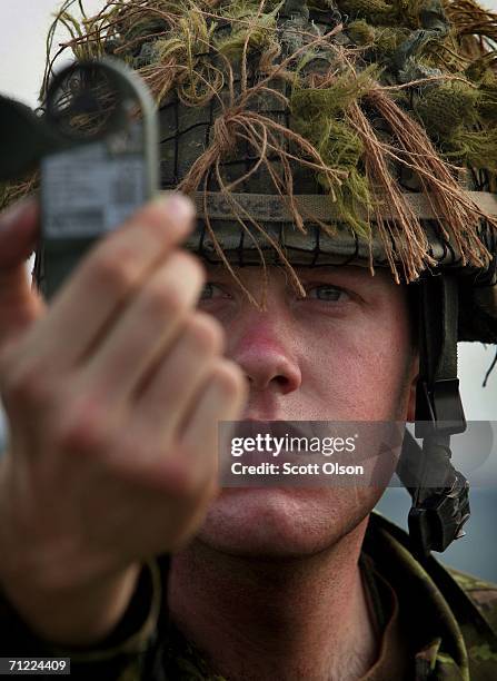 Corporal Greg Royce of the 3rd Battalion of the Royal Canadian Regiment out of Petawawa, Ontario, Canada checks wind speed for a parachute drop as...