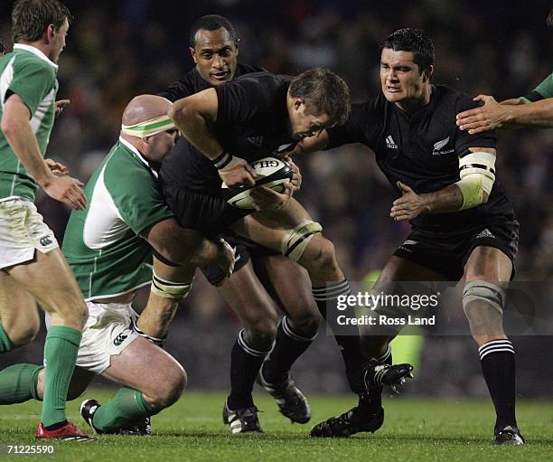 Richie McCaw Captain of the All Blacks is tackled by John Hayes of Ireland as Joe Rokocoko and Troy Flavell of the All Blacks back up and Rodney...