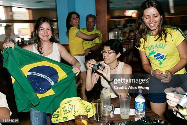 Exchange student from Brazil, Patricia Veridiano, Flavia Martins and Lucilene Gomes, along with other fans celebrate while they watch a live...