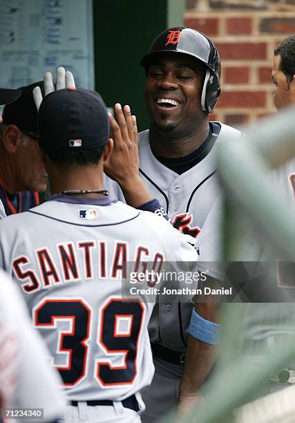 Marcus Thames of the Detroit Tigers smiles as he is greeted by teammate Ramon Santiago after hitting a solo home run in the 5th inning against the...