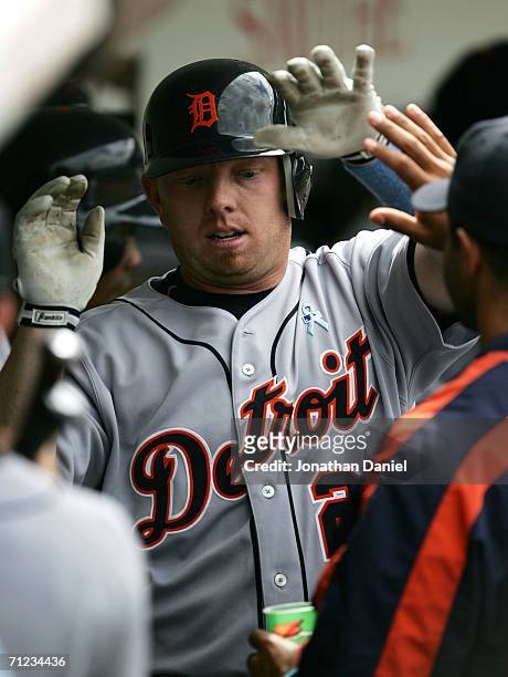 Chris Shelton of the Detroit Tigers is congratulated by teammates in the dugout after hitting his second home run of the game against the Chicago...