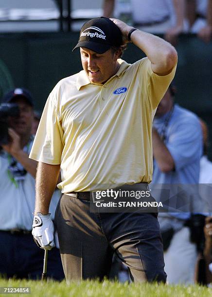 Mamaroneck, UNITED STATES: Phil Mickelson of the US holds his head after hitting a shot out of a sandtrap on the 18th green during the US Open...