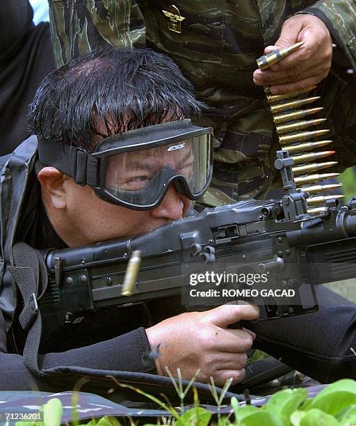 Sangley Point, PHILIPPINES: Armed forces chief General Generoso Senga fires an M-60 machine gun during a visit at the Naval Special Operations Group,...