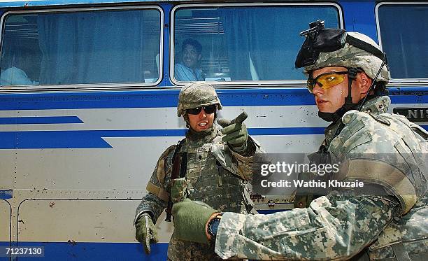 Soliders stand guard as freed Iraqi prisoners are seen inside a bus on June 19, 2006 at Abu Ghraib prison west of Baghdad, Iraq. More than 300...