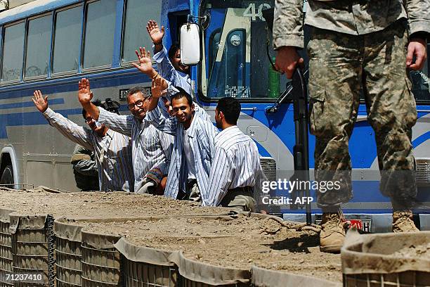 Solider stands guard freed Iraqi prisoners as they wave before they released 19 June 2006 at Abu Ghraib prison west of Baghdad, Iraq. Iraq released...