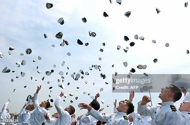 Graduates of the Class of 2006 toss their caps in the air in a traditional ceremony during commencement exercises at the US Merchant Marine Academy's...