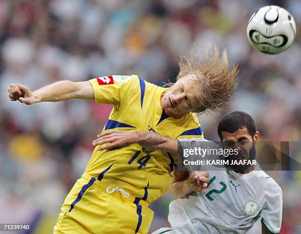 Ukrainian midfielder Andriy Gusin heads the ball with Saudi defender Abdulaziz Khathran during the World Cup 2006 group H football match Saudi Arabia...