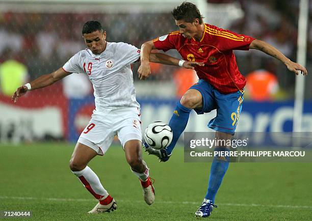 Tunisian defender Anis Ayari fights for the ball with Spanish forward Fernando Torres in the opening round Group H World Cup football match between...