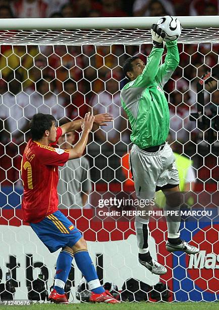 Tunisian goalkeeper Ali Boumnijel grabs a shot as Spanish forward David Villa looks on during the opening round Group H World Cup football match...