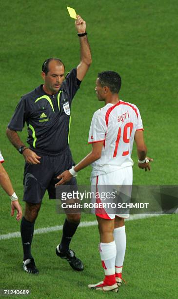 Referee Carlos Simon of Brazil issues a yellow card to Tunisian defender Anis Ayari during the opening round Group H World Cup football match between...