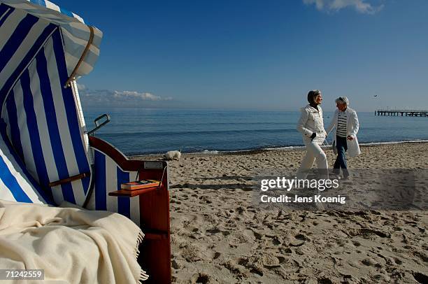 two mature women walking along the baltic sea - niendorf stock-fotos und bilder
