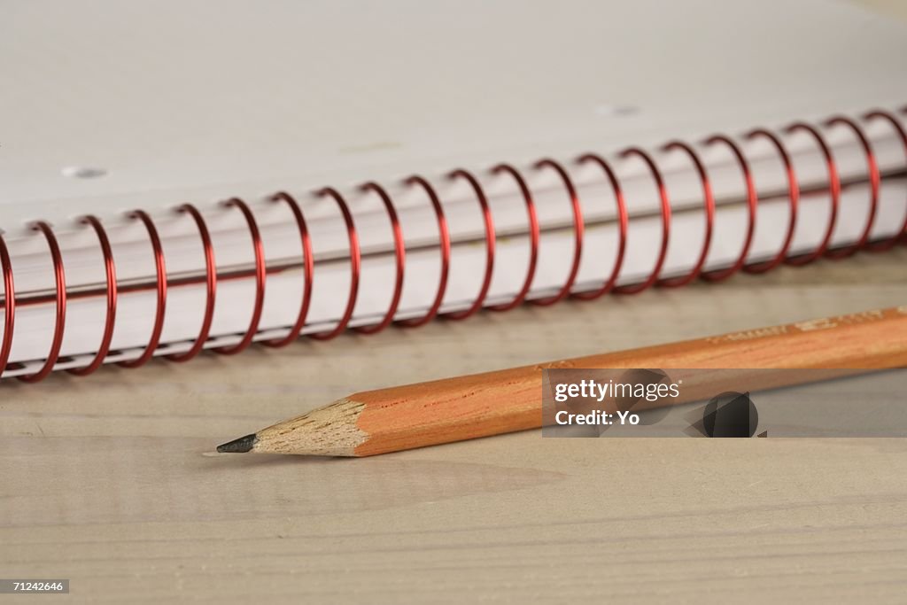 Pencil beside a writing pad