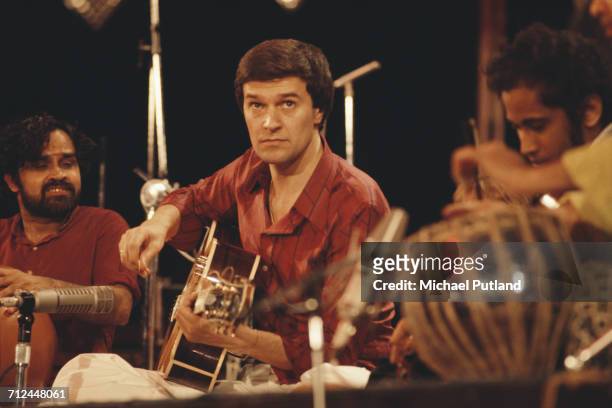 English guitarist and composer John McLaughlin performs live on stage playing an acoustic guitar with Shakti in New York on 30th July 1976.