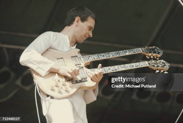 English guitarist and composer, John McLaughlin performs live on stage playing a double neck guitar at a festival in the United Kingdom on 7th...