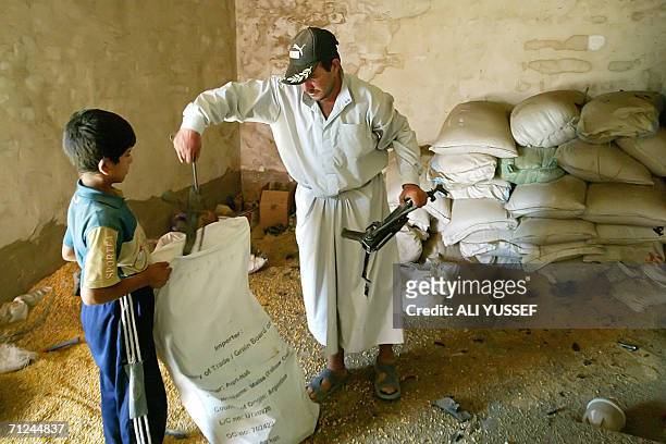 An Iraqi puts in a plastic bag a broken machinegun that allegedly belongs to one of what Iraqi civilians claim is one of 12 poultry farm workers, who...