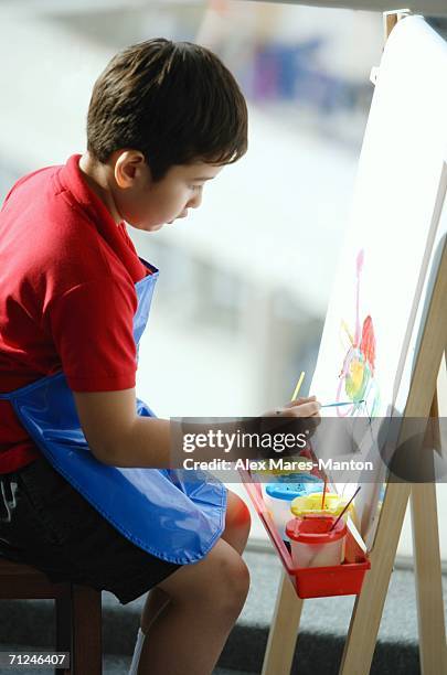 boy sitting in front of easel, painting - alex boys stockfoto's en -beelden