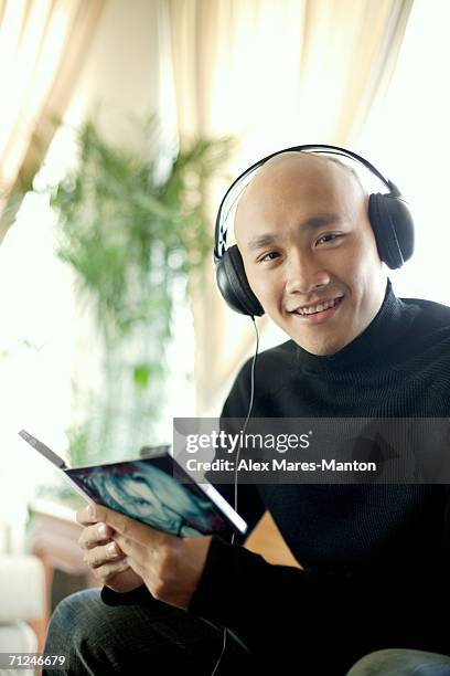 man in black turtleneck, wearing earphones, looking at camera - cd case stock pictures, royalty-free photos & images