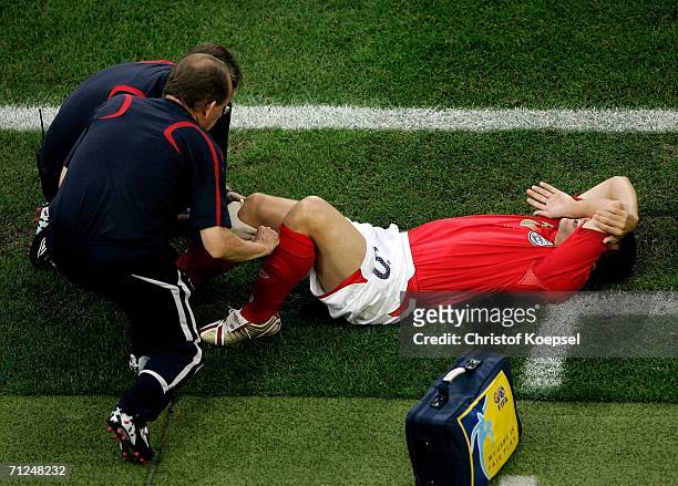 Michael Owen of England goes down injured during the FIFA World Cup Germany 2006 Group B match between Sweden and England at the Stadium Cologne on...