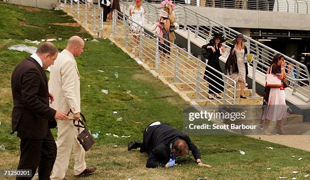 Man falls over as race-goers walk past him on the first day of Royal Ascot, at the Ascot Racecourse on June 20, 2006 in Ascot, England. The event has...