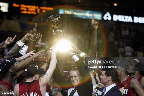 Dallas, UNITED STATES: Light is reflected off the Larry O'Brian trophy as Miami Heat head coach Pat Riley and the Heat celebrate winning Game Six of...