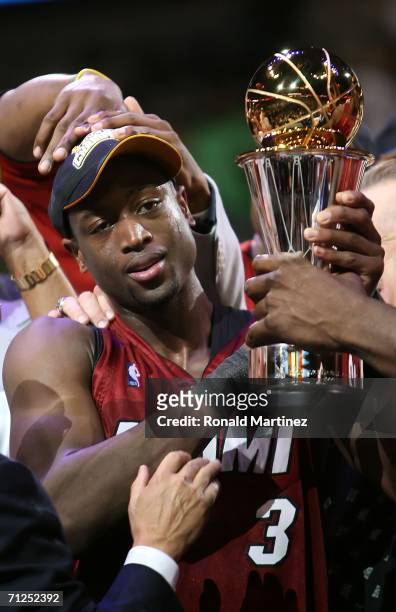 Dwyane Wade of the Miami Heat holds up the MVP trophy after the Heat defeated the Dallas Mavericks in game six of the 2006 NBA Finals on June 20,...