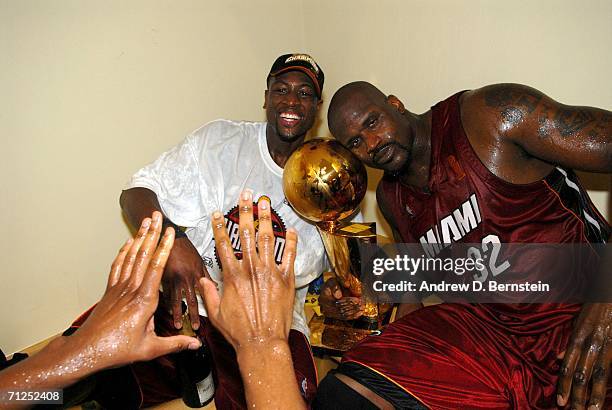 Dwyane Wade and Shaquille O'Neal of the Miami Heat celebrate with the Larry O'Brien Championship trophy after their Game Six victory of the 2006 NBA...