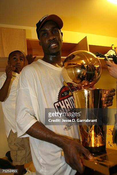 Gary Payton of the Miami Heat celebrates with the Larry O'Brien trophy in the locker room after they won the NBA Championship with their 95-92 win...